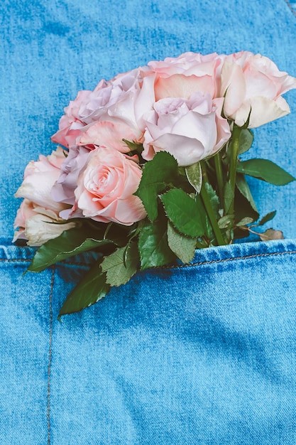 Bouquet of delicate roses in denim pocket