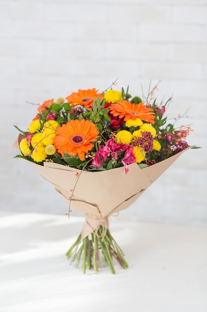 Bouquet of different flowers for holidays on white table