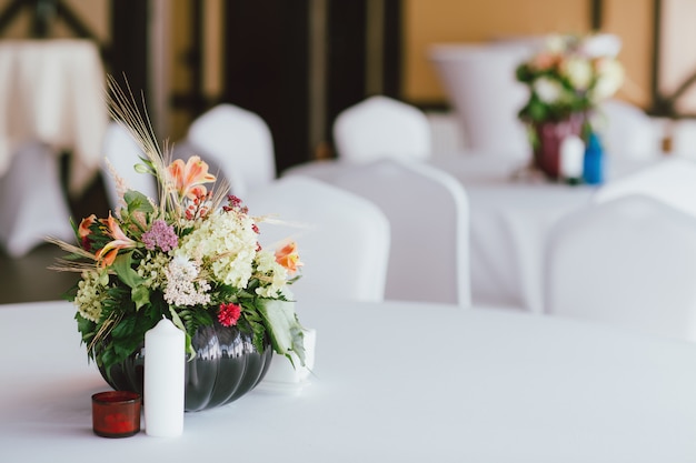 テーブルの結婚式の花瓶にさまざまな花の花束