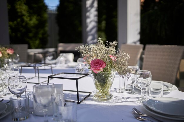 bouquet of dried flowers in a glass vase on a white tableclothWedding decorations on a wooden table