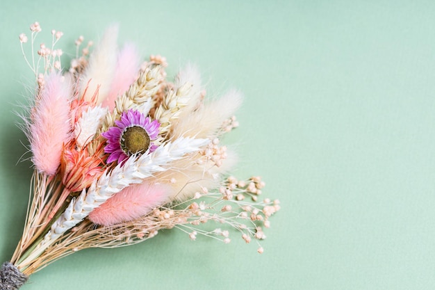 Bouquet of dried flowers and spikelets on green