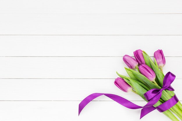 Bouquet of five tulips with ribbon bow on white