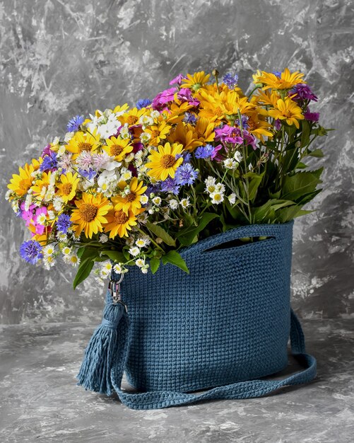 A bouquet of flowers in a bag blue yellow pink summer bag