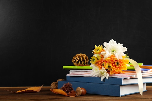 Bouquet of flowers and books on wooden table