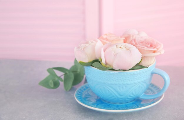 Bouquet of flowers in a cup on a grey table