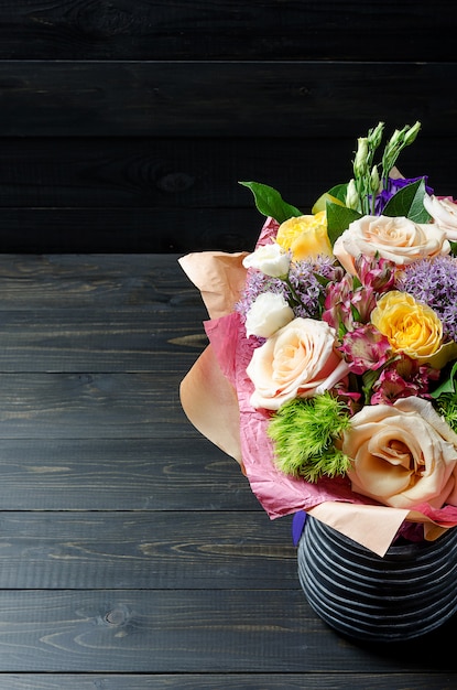 A bouquet of flowers on a dark wooden background. Bouquet with roses.