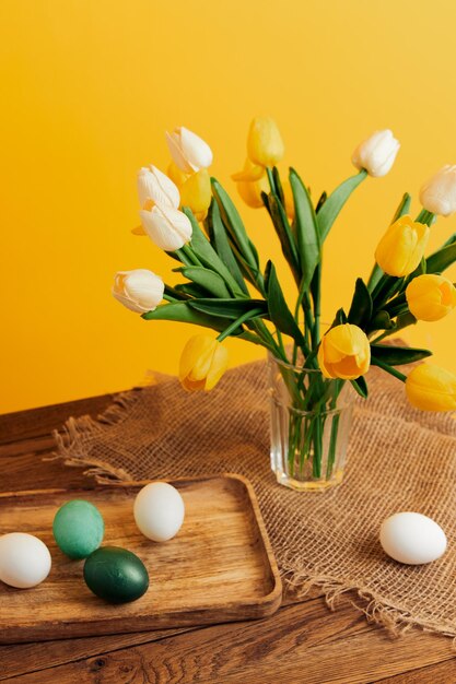 Bouquet of flowers easter eggs holiday decoration yellow background