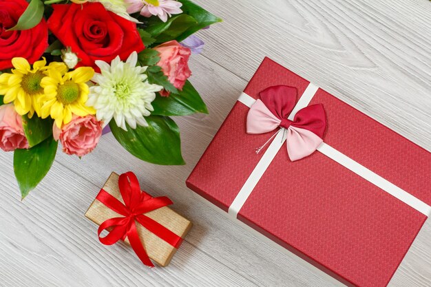 회색 나무 판자에 꽃다발과 선물 상자. 평면도.