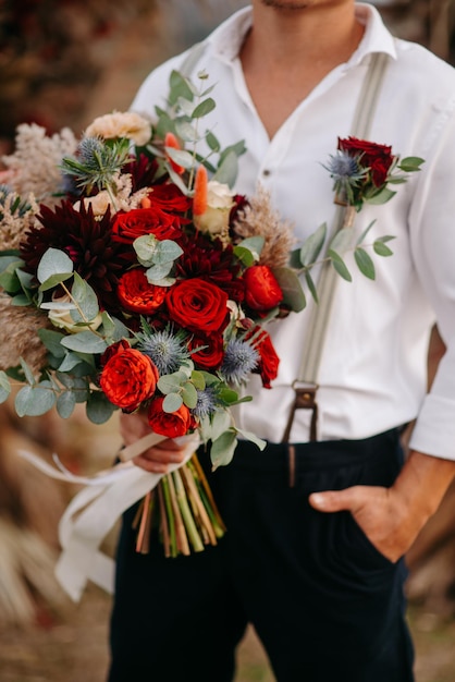 bouquet of flowers to the groom in his hands