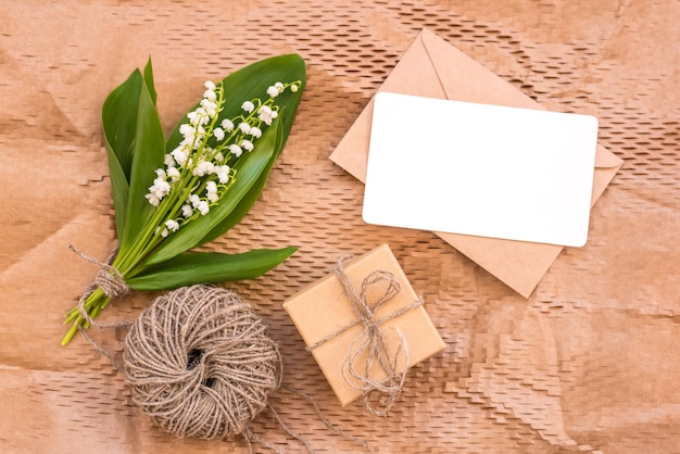 Bouquet of flowers lily of the valley and empty paper sheet