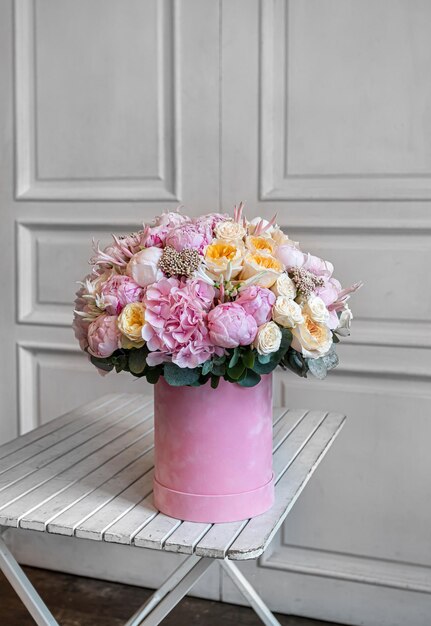 a bouquet of flowers in a pink round box of hydrangea ozothamnus peony spray rose peony rose