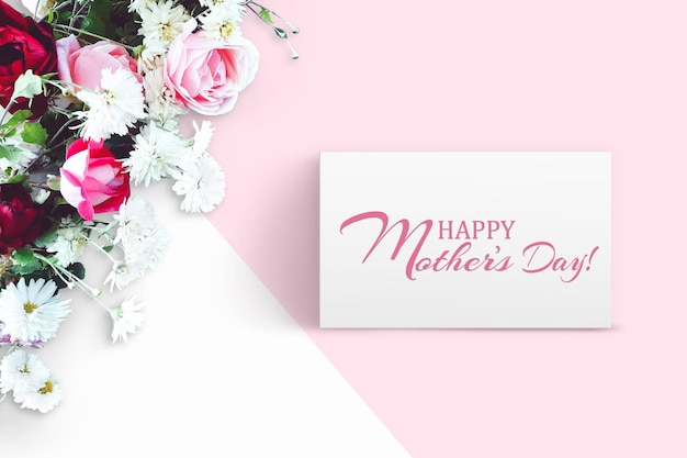 Bouquet of flowers, red and pink roses, white daisies on white and pink background. Inscription Happy Mother's Day. Advertising content  for Mother's Day. Flat lay, top view, close up, copy space