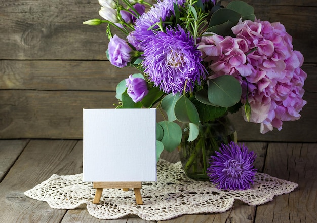 A bouquet of flowers and a small easel with a blank sheet of paper