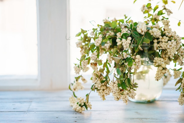 A bouquet of flowers stands on the window sill and the window