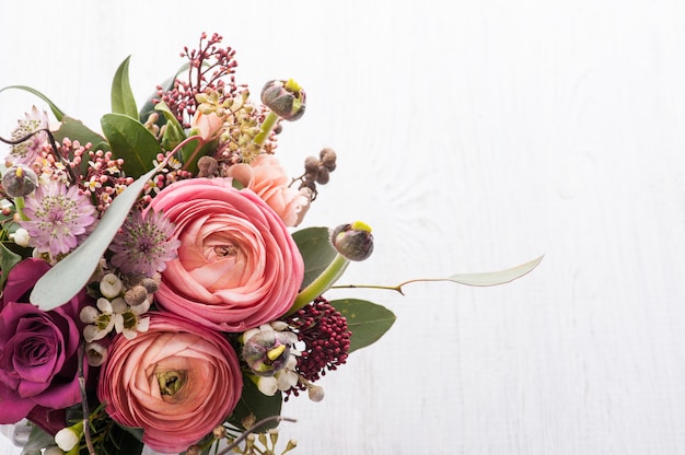 Bouquet of flowers in tin mug on light background