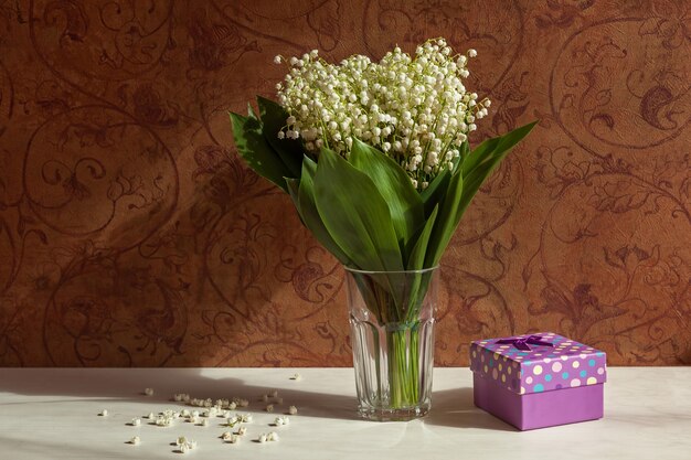 Bouquet of flowers in a vase on the background of dark wallpapers with a pattern