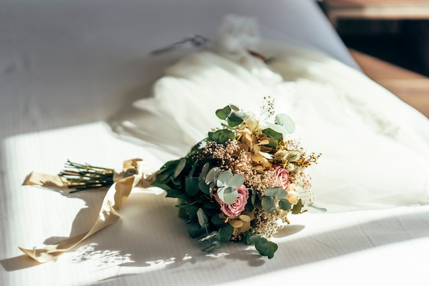 Foto bouquet di fiori su un letto bianco.