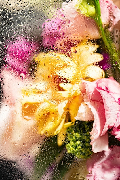 a bouquet of flowers with water drops on the glass