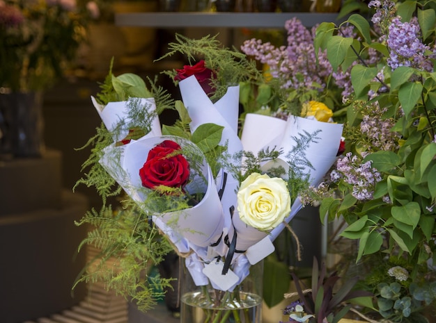 A bouquet of flowers with a white ribbon that says " love " on it.