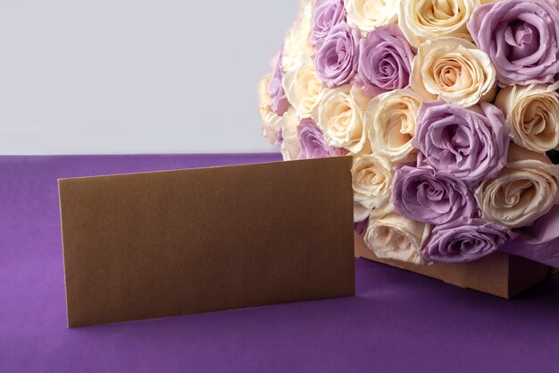 Bouquet of fresh amazing white and purple roses and craft envelope.