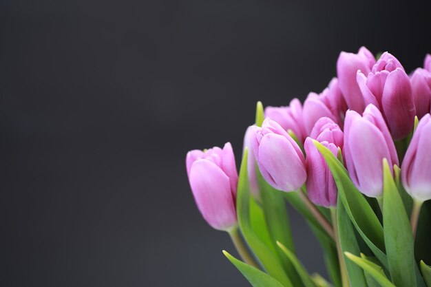 生花の花束。あなたの愛する人へのホリデーギフト。背景聖バレンタインデー。バラ、チューリップ、アイリスのフラワーアレンジメント。