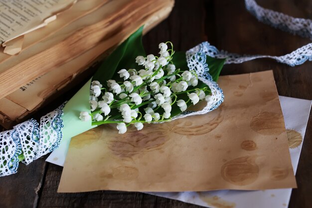 Bouquet of fresh lilies of the valley and retro book