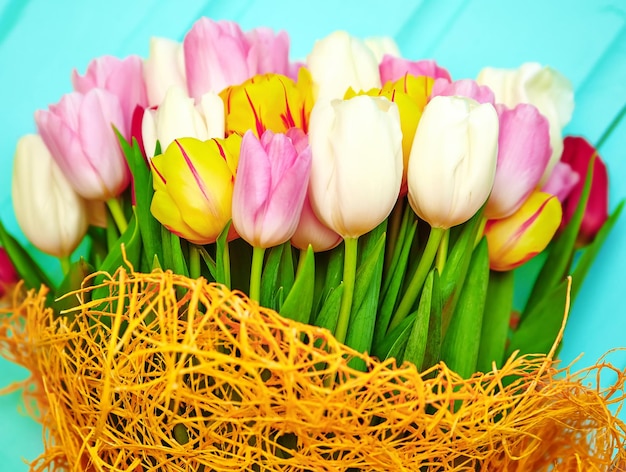 Bouquet of fresh multicolor tulip flowers on old blue wooden table