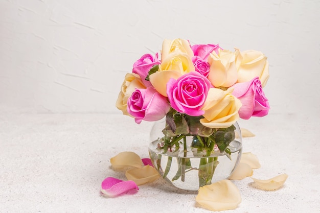 花瓶に新鮮な色とりどりのバラの花束。結婚式、誕生日、3月8日、母の日、またはバレンタインデーのお祝いのコンセプト。グリーティングカード、明るい背景