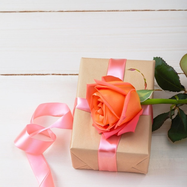 Bouquet of fresh pink Marguerite daisy flowers and small gift box lying on light background Spring