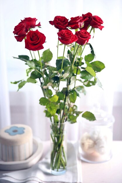 Bouquet of fresh red roses on windowsill background