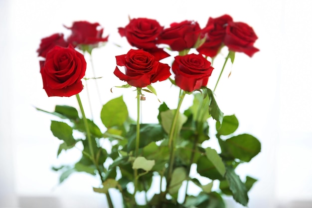 Букет свежих красных роз на фоне подоконника