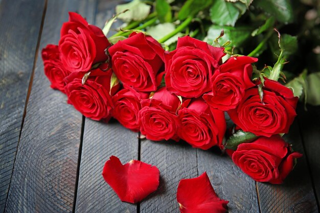 Bouquet of fresh red roses on wooden background