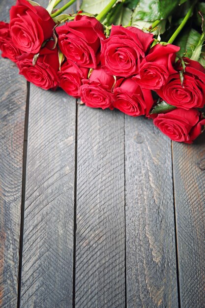 Bouquet of fresh red roses on wooden background