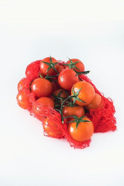 Bouquet of fresh ripe cherry tomatoes ready to eat on a bright white background