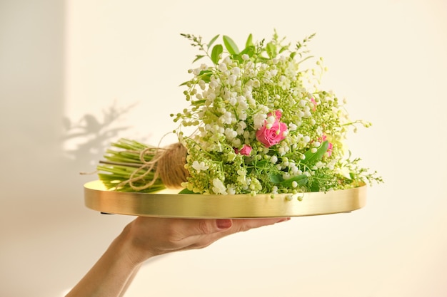 Bouquet of fresh spring flowers of pink rose, lily of the valley