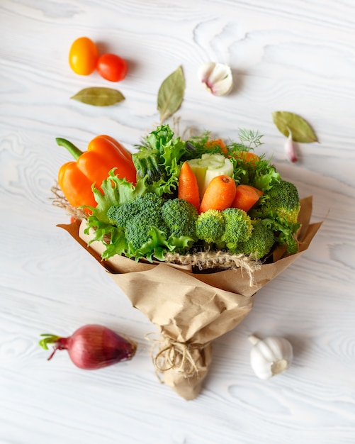 Bouquet of fresh vegetables on a white wooden table