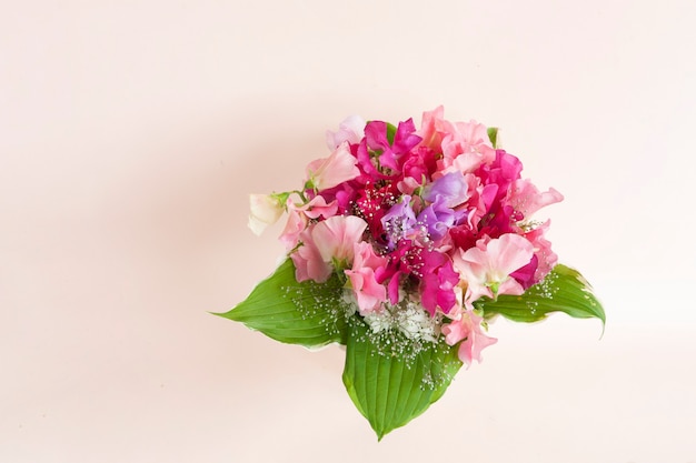 Bouquet of fresh vivid sweet pea flowers in a vase