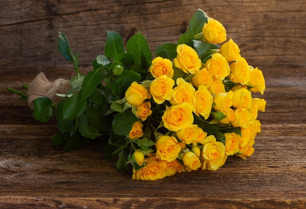 Bouquet of fresh yellow roses on wooden