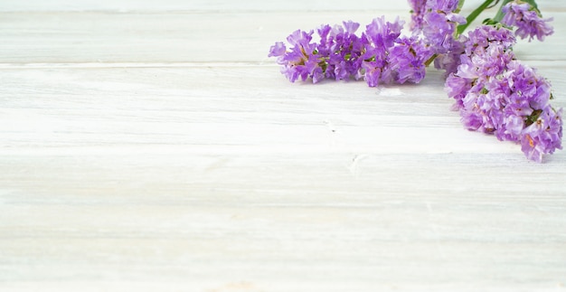 Bouquet from purple statice flowers on a white wooden table 