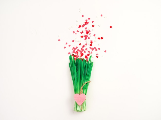 A bouquet of grass and small hearts. Top View. The concept of Valentine's day.