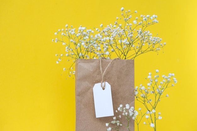 A bouquet of gypsophila flowers in a kraft bag with a white cardboard label layout