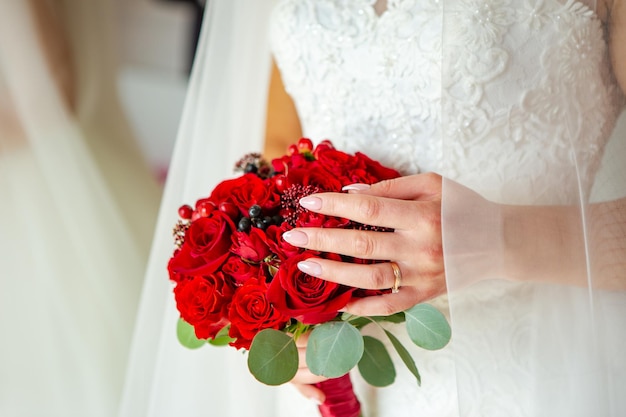 Bouquet in the hands of the bride Wedding bouquet of red roses