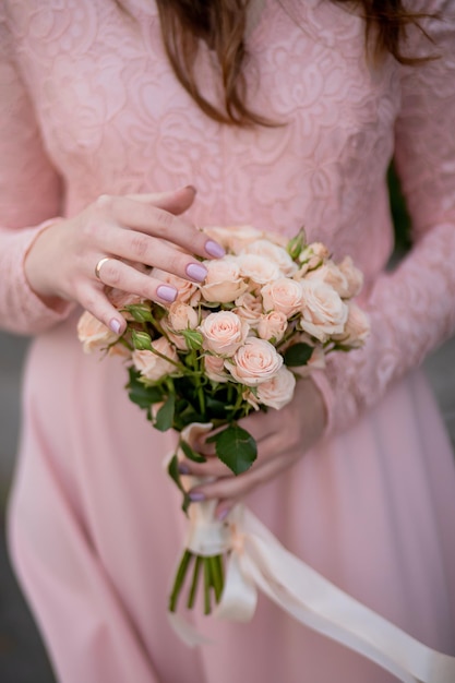 Bouquet in hands of the bride woman getting ready before wedding ceremony