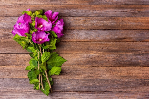 A bouquet of hibiscus flowers on a vintage wooden background with copy space