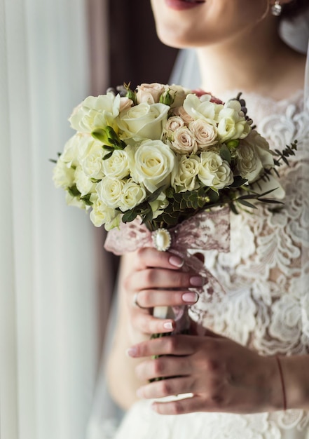 写真 結婚式の前に準備をしている花嫁の女性の手に花束