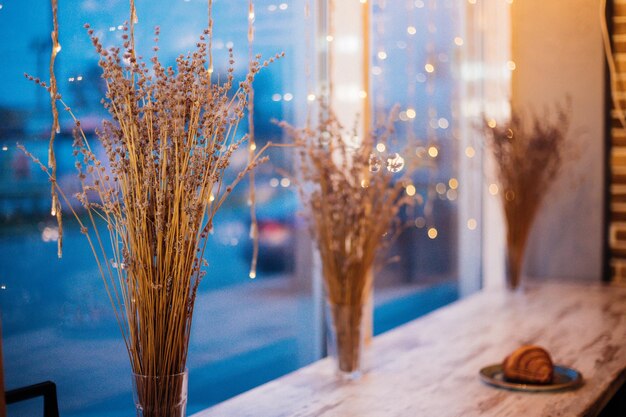 花輪の背景にある窓辺のドライフラワーからラベンダーの花束。お祭りの雰囲気。ぼやけたライト。