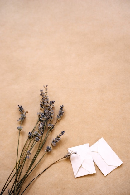 A bouquet of lavender and two small handmade envelopes on craft paper for packaging.