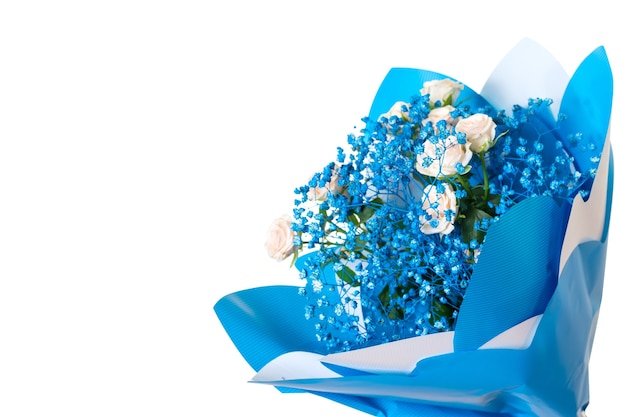 Bouquet of light roses and small blue flowers isolated on a white surface