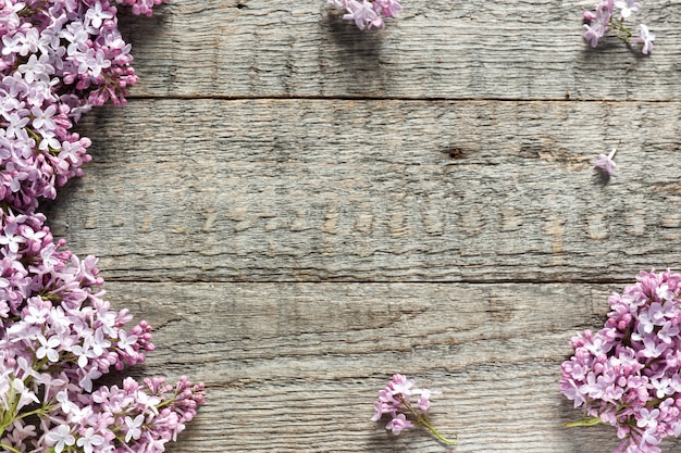 Bouquet of lilac flowers on wooden background. Copy space.