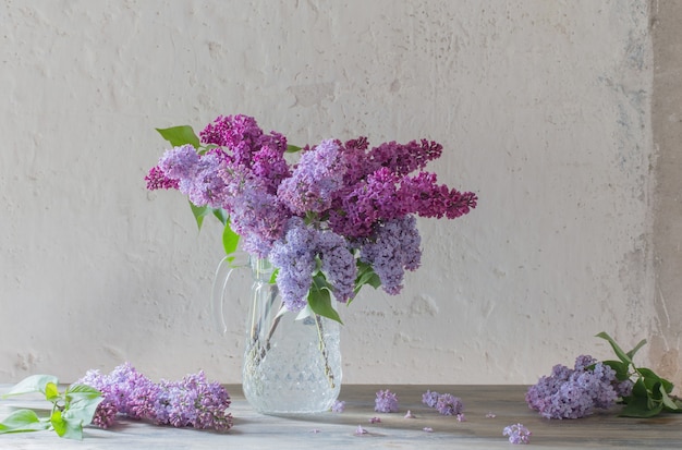 ガラスの水差しのライラックの花束